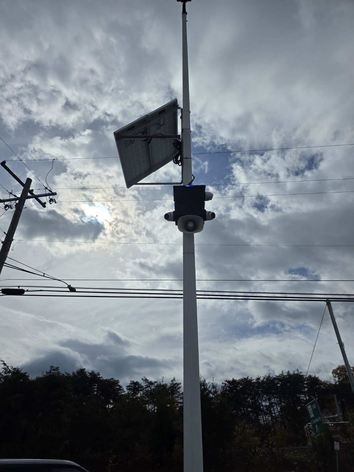 Close view from below of a solar surveillance enclosure with cameras and speaker